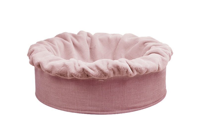 Rundes, weiches Hundebett Buddelnest® in sanftem Rosa mit gerafftem Rand und pflegeleichtem Material. Ideal für entspannte Hundemomente.