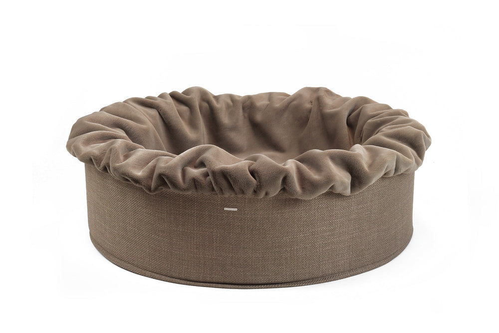 Hundebett Buddelnest® in rundem Design mit hoher, weicher Rand, neutraler brauner Farbe und gerafftem Bezug.