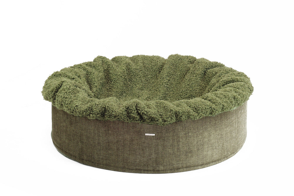 Rundes Hundebett Buddelnest® in olivgrün mit weichem Innenbereich und robustem äußeren Rand.