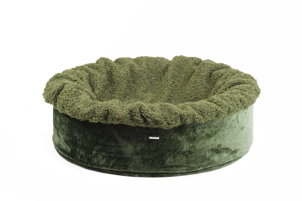 Rundes, weiches Hundebett Buddelnest® in Olivgrün mit plüschigem Rand und glatter Bodenfläche.