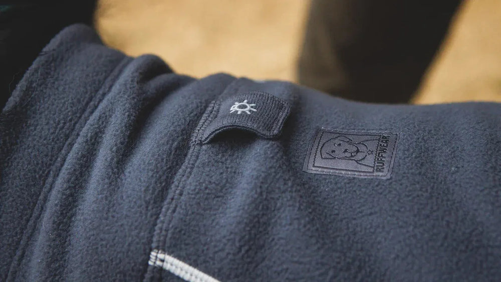Dunkelblaue Climate Changer™ Fleecejacke mit gesticktem Tier-Logo und Sonnensymbol auf der oberen linken Seite.