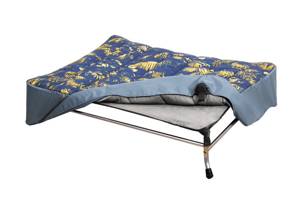 "Zusammenklappbare Hundeliege mit blauer und gelber Matratze im floralen Design auf stabilem Metallrahmen."