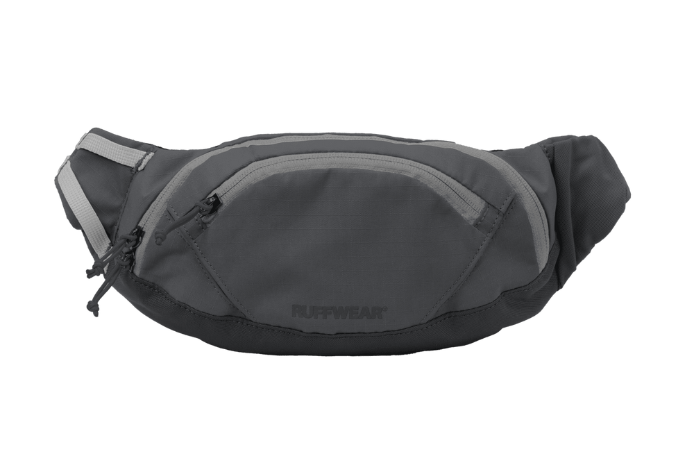 Graue Ruffwear Home Trail™ Hüfttasche mit geschwungener Form, Hauptfach, vorderem Reißverschluss und reflektierenden Elementen.