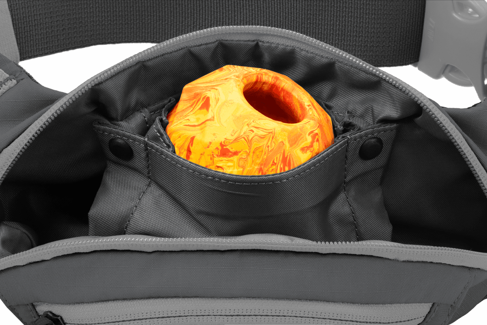 Graue Home Trail™ Hüfttasche mit geöffnetem Reißverschluss und orange-gelben, marmorierten Objekt im Inneren.
