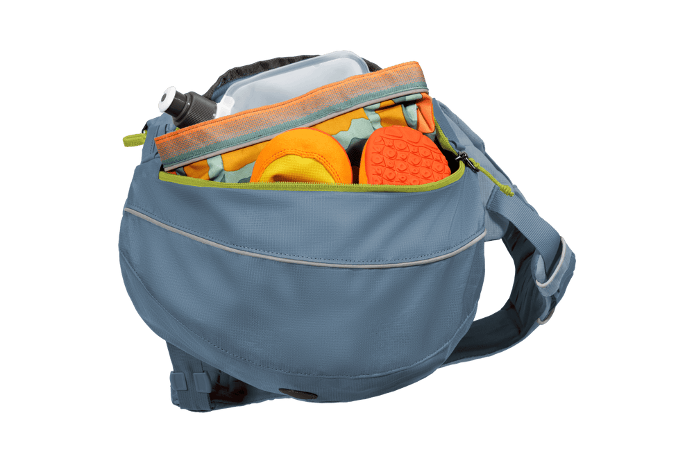 Hellblaue Gürteltasche mit Wasserflasche und orangefarbenen Spielzeugen für Hunde, geöffnet für einen Blick ins Innere.