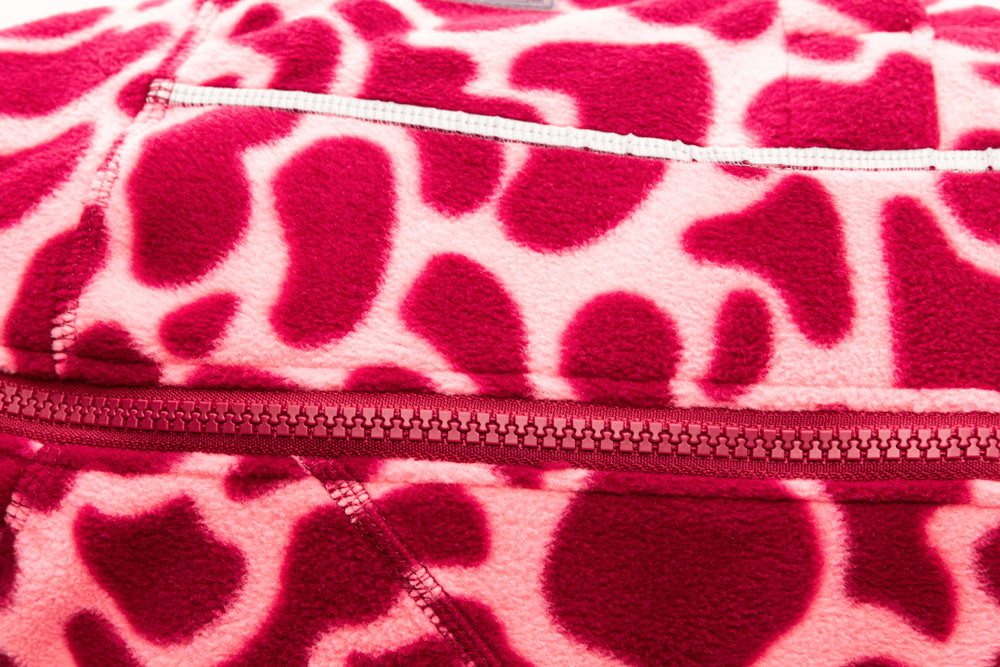 Leuchtende pinke und rote Fleecejacke mit Giraffenmuster und durchgehendem Reißverschluss. Ideal für warme Outfits.