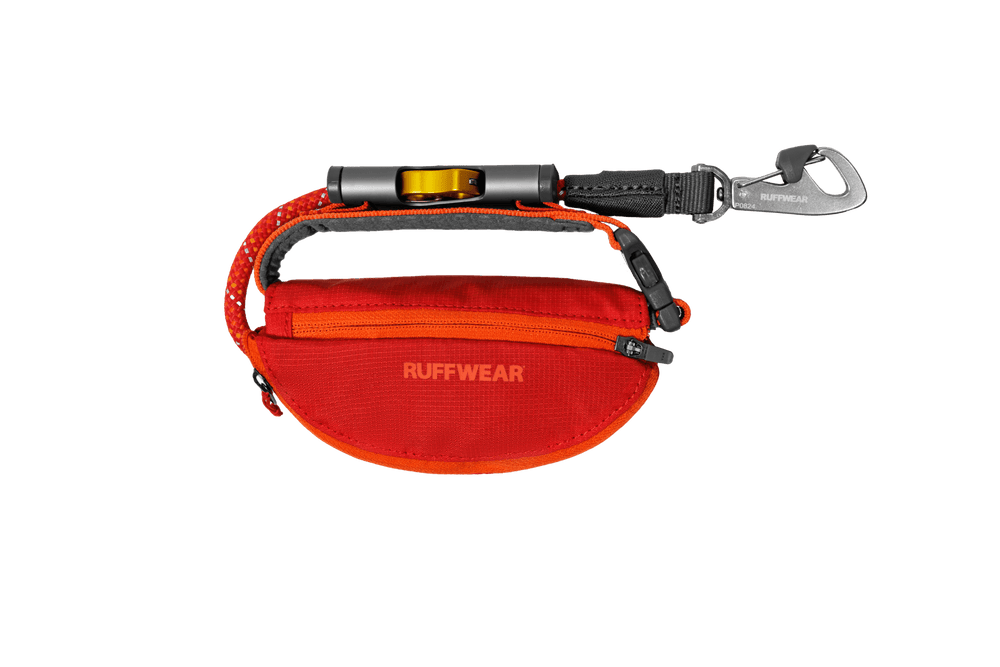 Orangefarbene Hundetasche von RUFFWEAR im halbrunden Design mit Reißverschluss und Karabinerhaken. Ideal für Abenteuer mit Ihrem Hund.