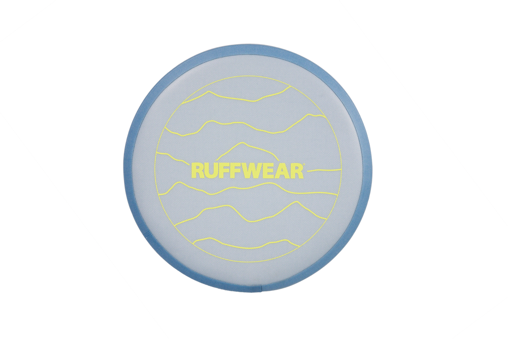 Camp Flyer™ Hundescheibe in hellblau mit gelber Schrift vor bergigem Hintergrund, ideal für aktive Hunde.