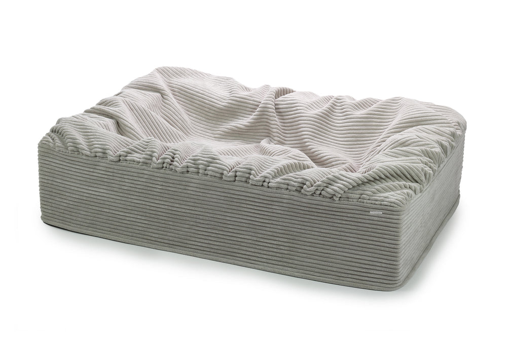 Grau gestreiftes Hundebett mit erhöhtem Rand, weich und plüschig, ideal für komfortable Ruhezeiten.
