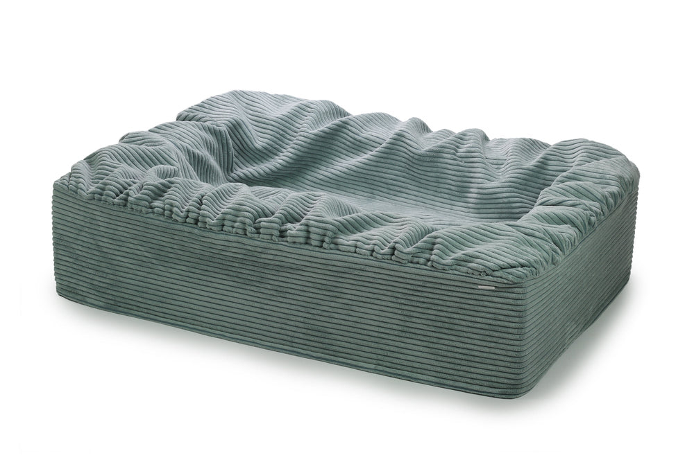 Rechteckiges hundefreundliches Bett mit weichem grauem Cordbezug und abgerundeten Kanten für optimalen Komfort.
