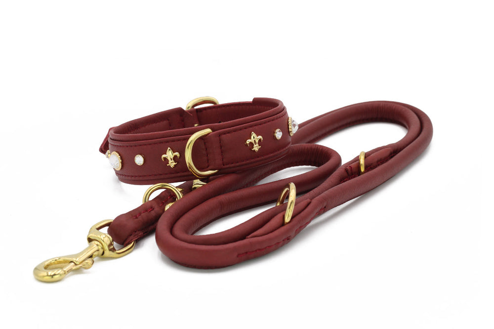 Dunkelrotes Hundehalsband mit goldfarbenen Fleur-de-Lys und passender Leine für stilvolle Hundefreunde.