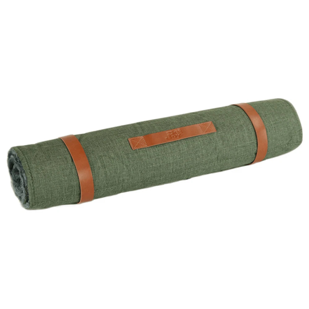Runde grüne Picknickdecke im Rollformat, mit braunen Lederbändern geschnallt und geprägtem Logo. Ideal für Ausflüge.