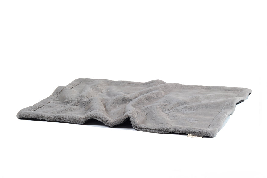 Graue Hundedecke aus Webpelz, weich und flauschig, gefaltet auf weißer Oberfläche. Ideal für gemütliche Stunden.