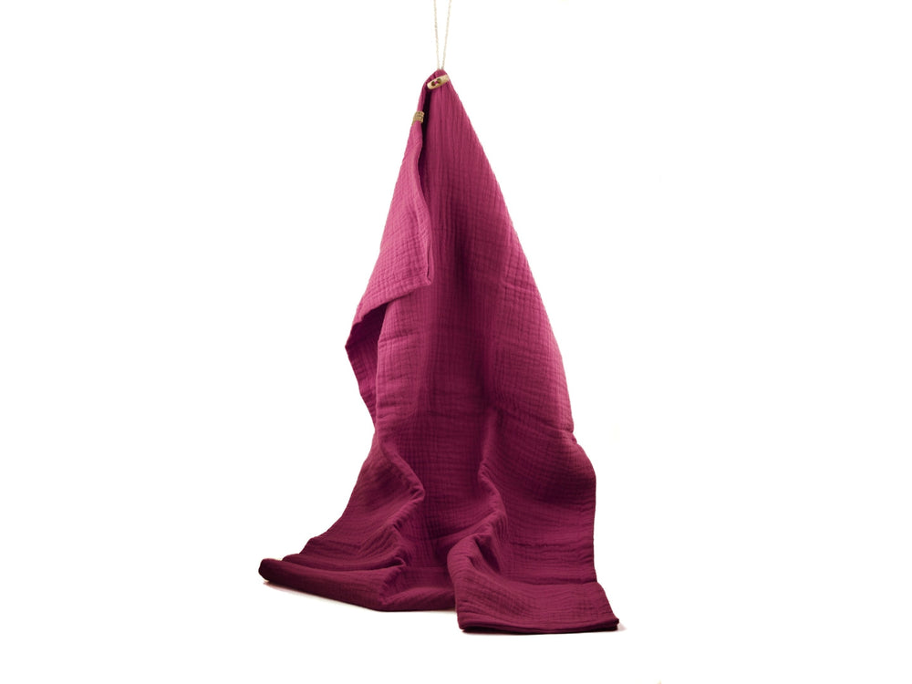 Rötliches Hundehandtuch 'Sparkle' mit strukturierter Oberfläche hängt an einem Haken, ideal für das Trocknen von Haustieren.