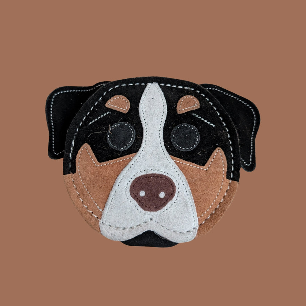Buntes, genähtes Hundespielzeug in Form eines Rottweiler-Kopfs aus verschiedenen Stoffen in Naturtönen.