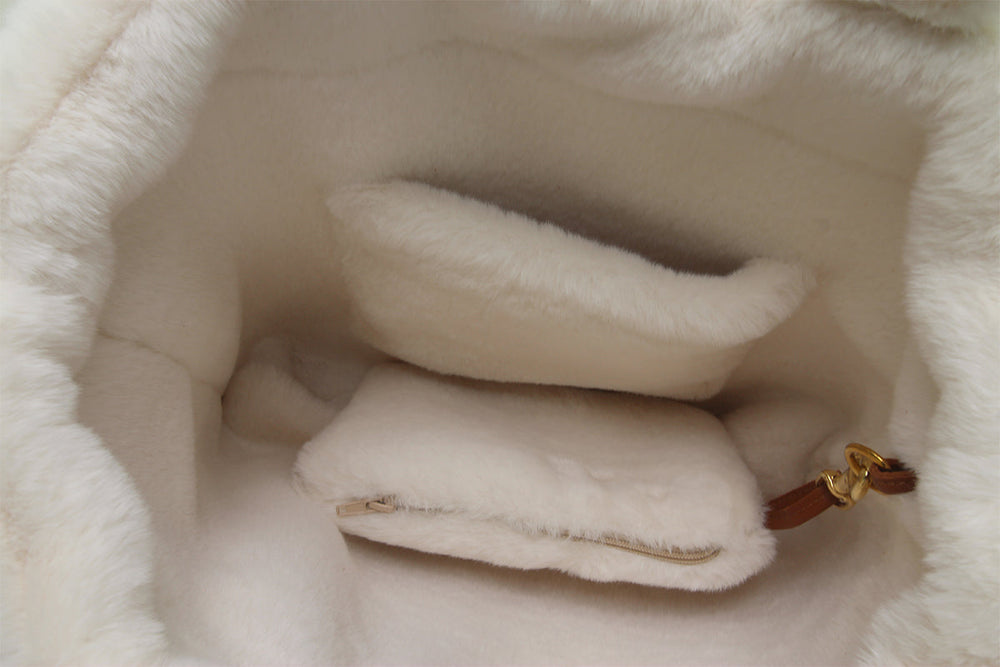 Innenansicht einer eleganten Handtasche mit hellem, fluffy Futter und zwei separaten Fächern.