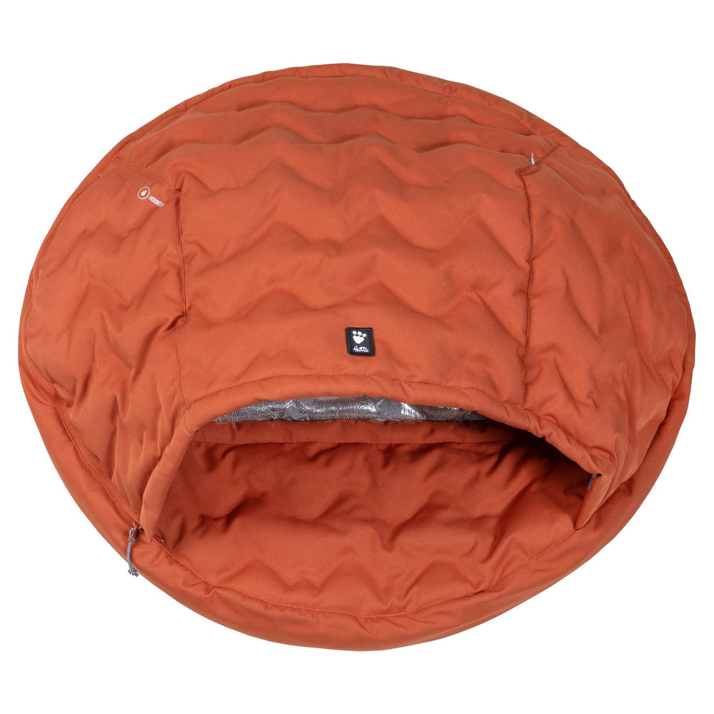 Hunde-Schlafsack Sleepover in Orange, rund und gepolstert, mit gesteppter Struktur und Öffnung, ideal als gemütliches Hundebett.