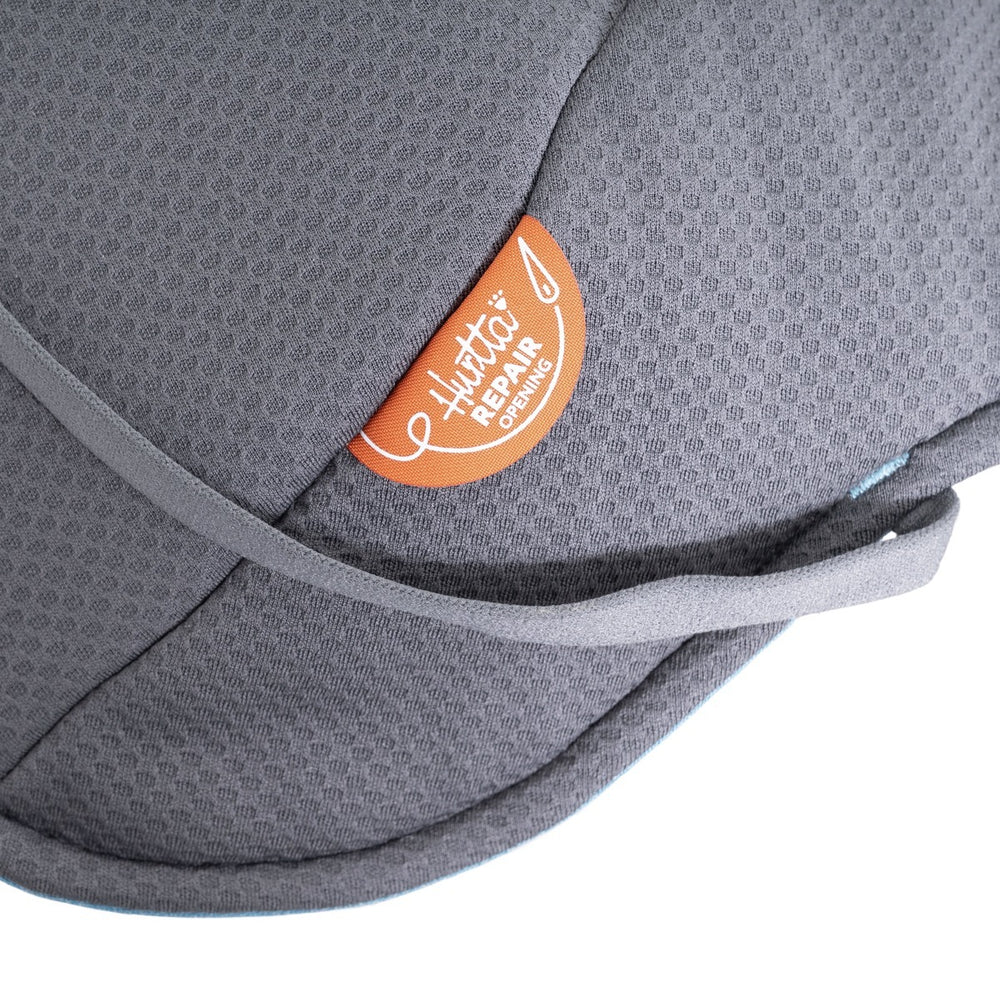 Grauer Stoff der Hundejacke Expedition Parka II mit orangefarbenem "Repair Opening"-Etikett und grauem Band.