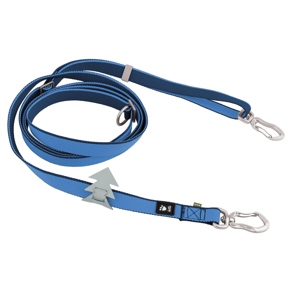 Blaue Nylon-Hundeleine Multilong Leash II mit silbernen Karabinerhaken, metallischen Ringen und Baum-Emblem zur Längenverstellung.