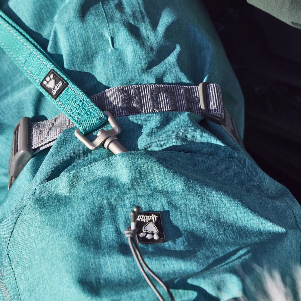 Blauer Regenmantel Monsoon Coat II ECO mit grauem Gurt und Pfotenabdruck-Etikett, ideal für umweltbewusstes Outdoor-Abenteuer.