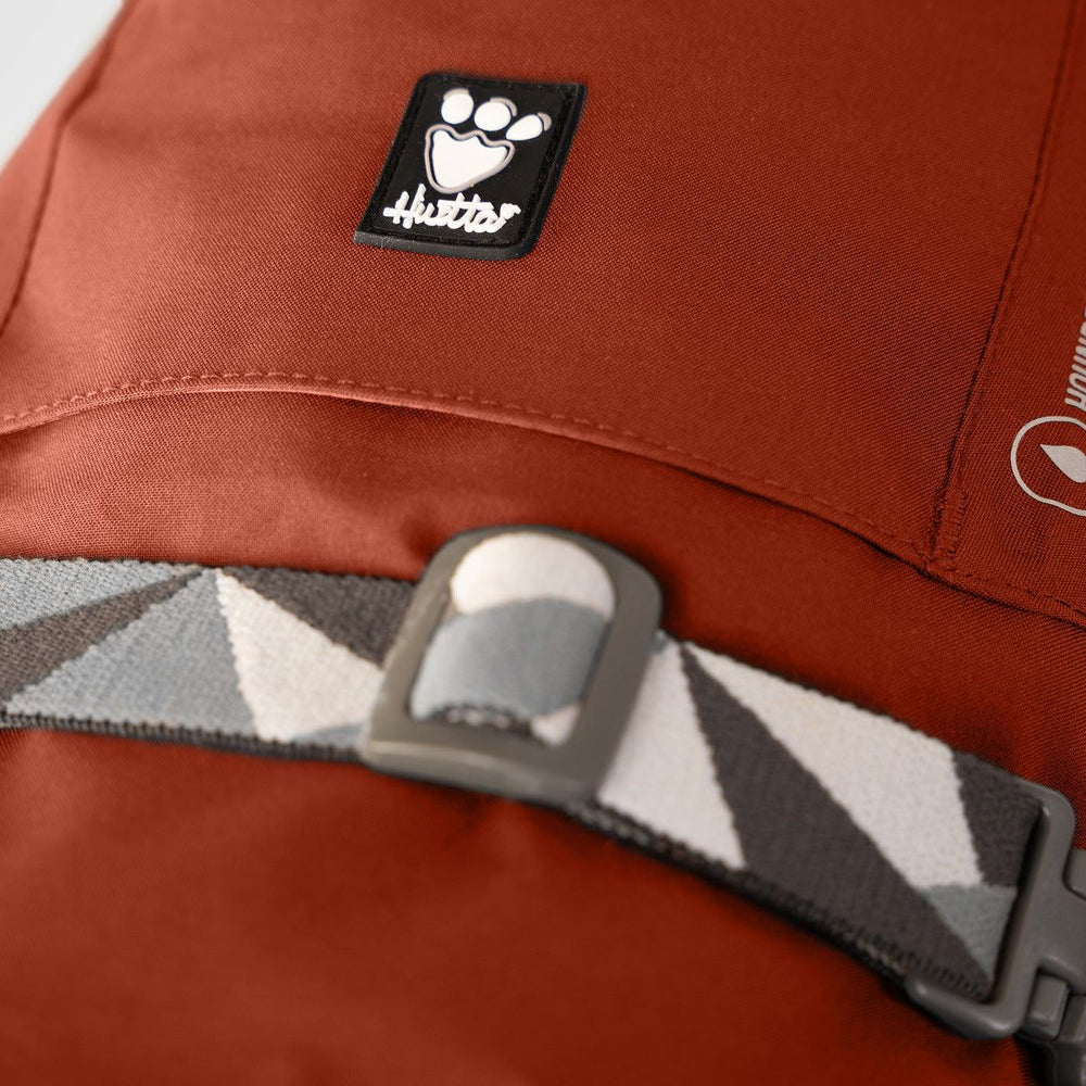 Rötlicher Mudventure Coat ECO Regenmantel mit Pfoten-Logo und Gürtel in geometrischem Muster in Grau, Weiß und Schwarz.