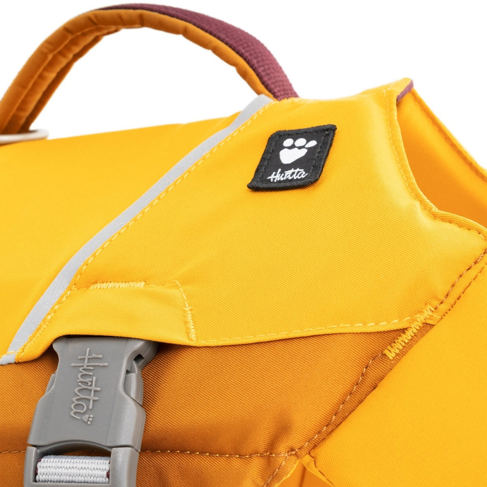 Gelber Rucksack mit grauem Verschluss und Markenlogo, gepolsterter Tragegriff, ideal für Wassersport und Freizeit.