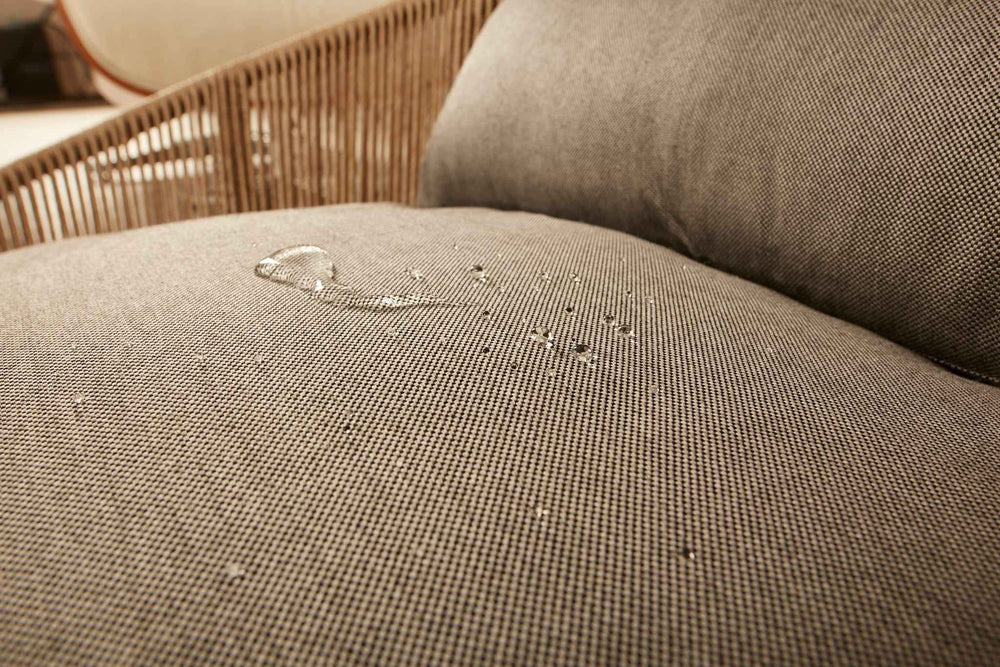 Nahaufnahme des ORTHO Hundebetts SMOOTH mit gepolsterter textile Oberfläche und sichtbaren Wassertropfen.