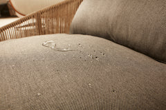 Wasserabweisender Textilstoff des CLASSIC Hundebetts SMOOTH mit Wassertropfen, Sitzlehne im Hintergrund sichtbar.