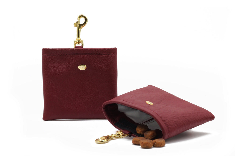 "Kleine burgunderrote Geldbörse aus Kunstleder mit Hundeleckerlis und goldenem Clip zum Befestigen."