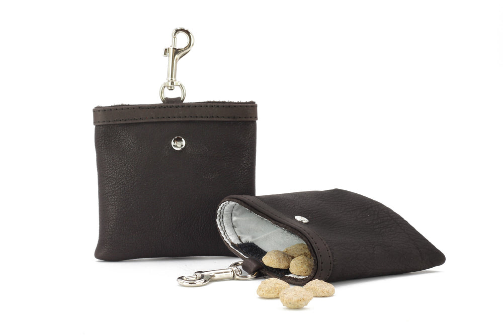 Schwarzes Leder-Mäppchen mit Karabinerhaken, geöffnet und gefüllt mit kleinen Leckerlis. Ideal für unterwegs!