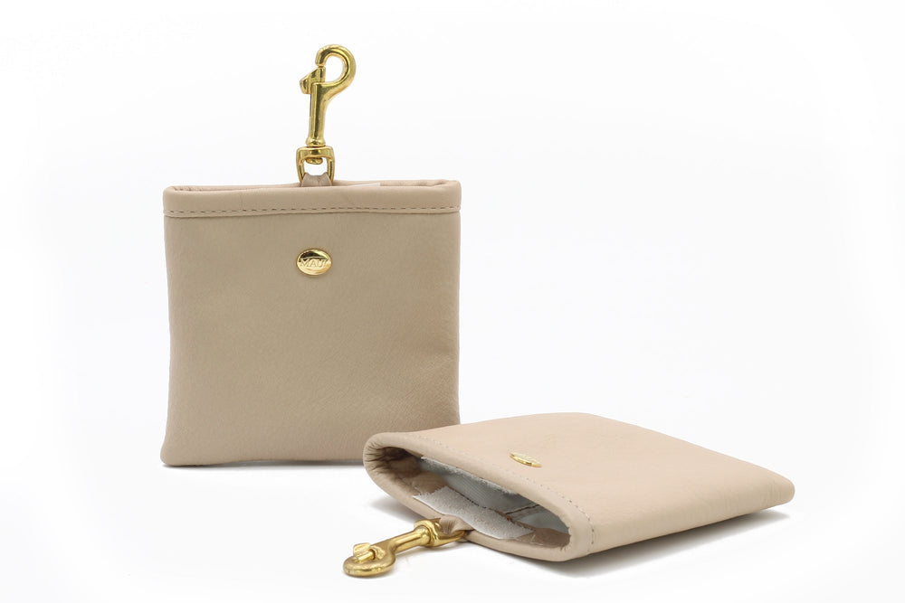 Hellbeiger Leder-Leckerli-Beutel mit Karabinerhaken, geöffnet und mit goldfarbenem Logo sichtbar.