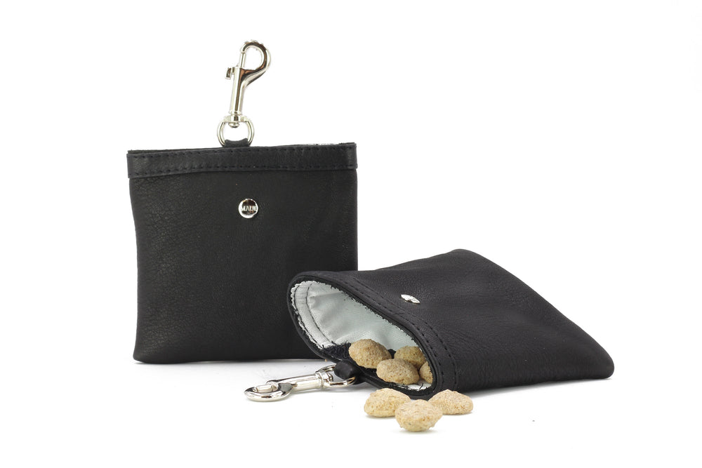 Zwei schwarze Leckerli-Beutel aus lederähnlichem Material mit hellbraunen Snacks, einer offen mit Snacks, beide mit Karabiner.