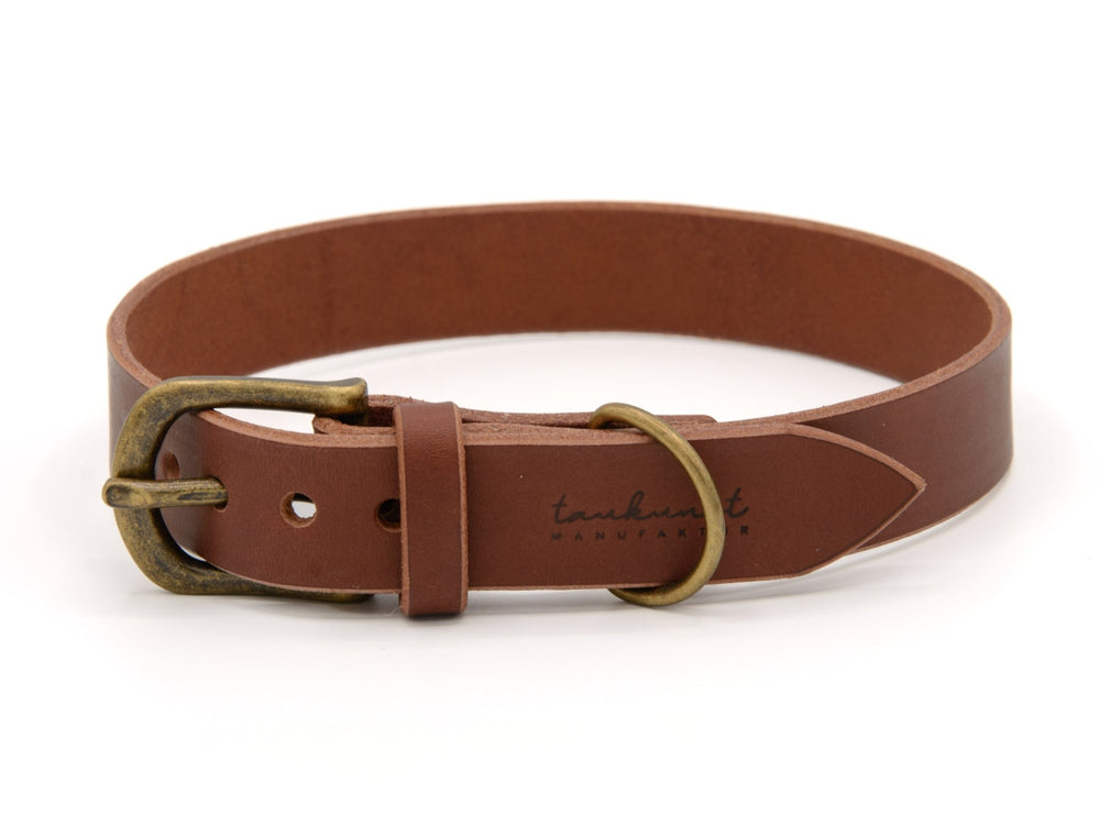 Brauner Leder-Gürtel WALDSTREUNER mit messingfarbener Schnalle und "tauthunt manufacturer" Logo auf der Innenseite.