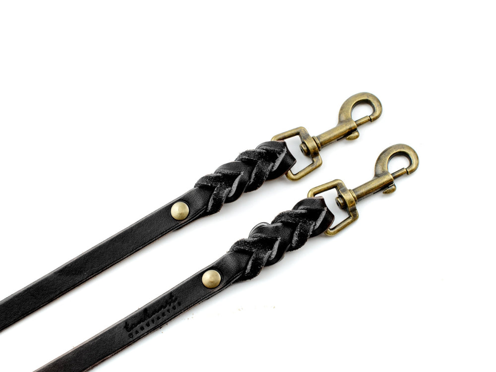 Schwarzes, geflochtenes Lederleine mit goldfarbenen Karabinerhaken für stilvolle Hundeführer.