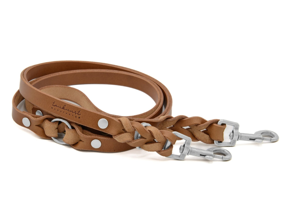 Braune Lederhunde­leine, schlicht und geflochten, mit robusten Metallschnallen für stilvolles Gassigehen.