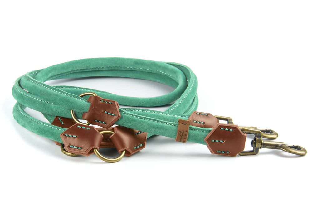 Grüne Wildlederleine mit braunen Lederdetails und Metallbeschlägen, doppelter Ausführung mit zwei Karabinerhaken.
