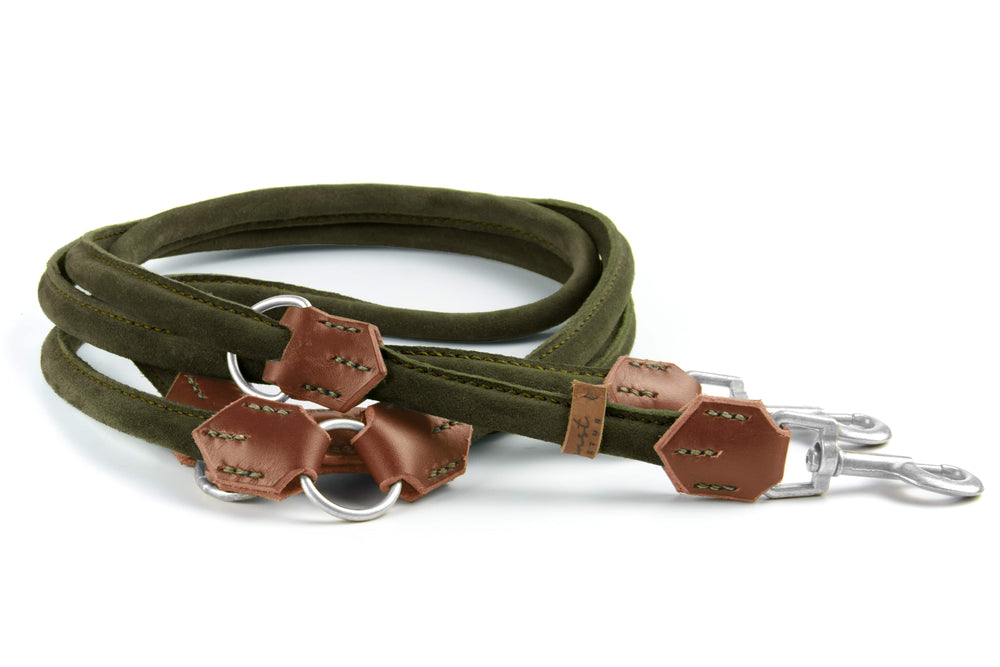 Grüne Wildlederleine „Wildfang“ mit Karabinerhaken und braunen Lederdetails, in spiralförmiger Anordnung.
