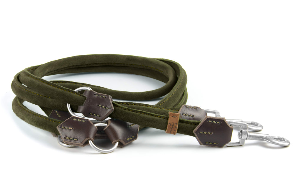 "Grüne Wildlederleine mit braunen Lederdetails und Metallkarabinern, hochwertig verarbeitet und geschwungen."