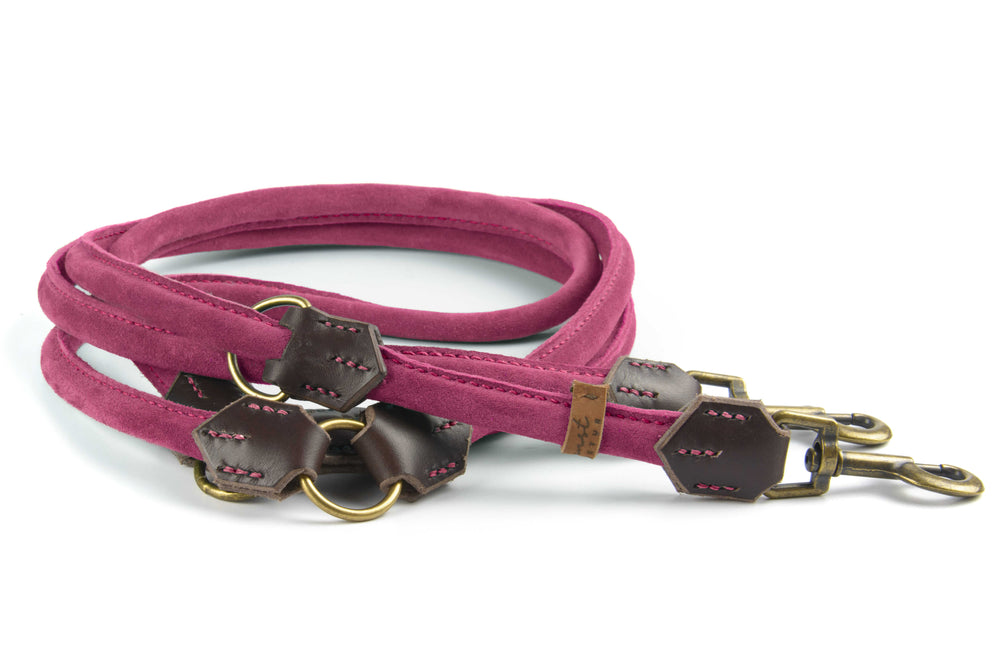 "Rosa Wildlederleine aus Veloursleder mit zwei Karabinerhaken und braunen Lederakzenten, hochwertig verarbeitet."
