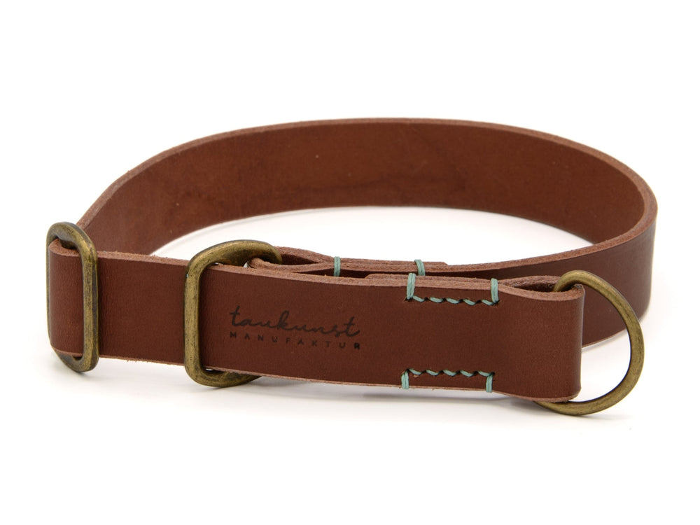 Brauner Ledergürtel mit silberfarbener Schnalle und Ziernähten, logo „tarnkunst MANUFAKTUR“ in eleganter Gestaltung.