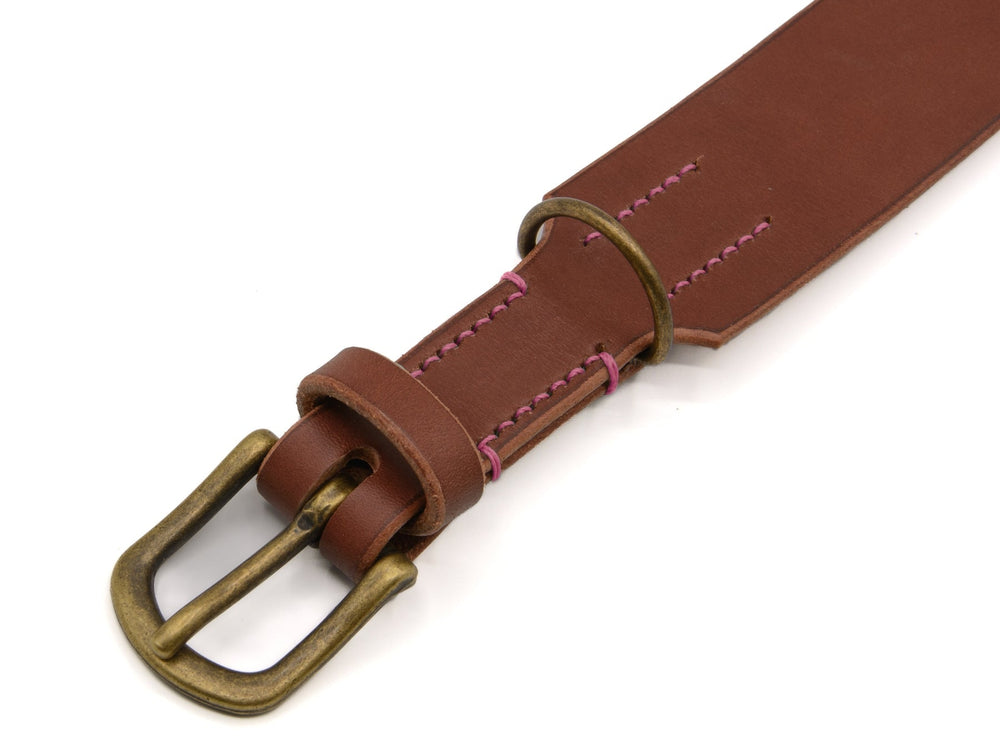 Brauner Ledergürtel mit mattschwarzer Messingschnalle und lila Steppnähten für einen stylischen Waldgeist-Look.