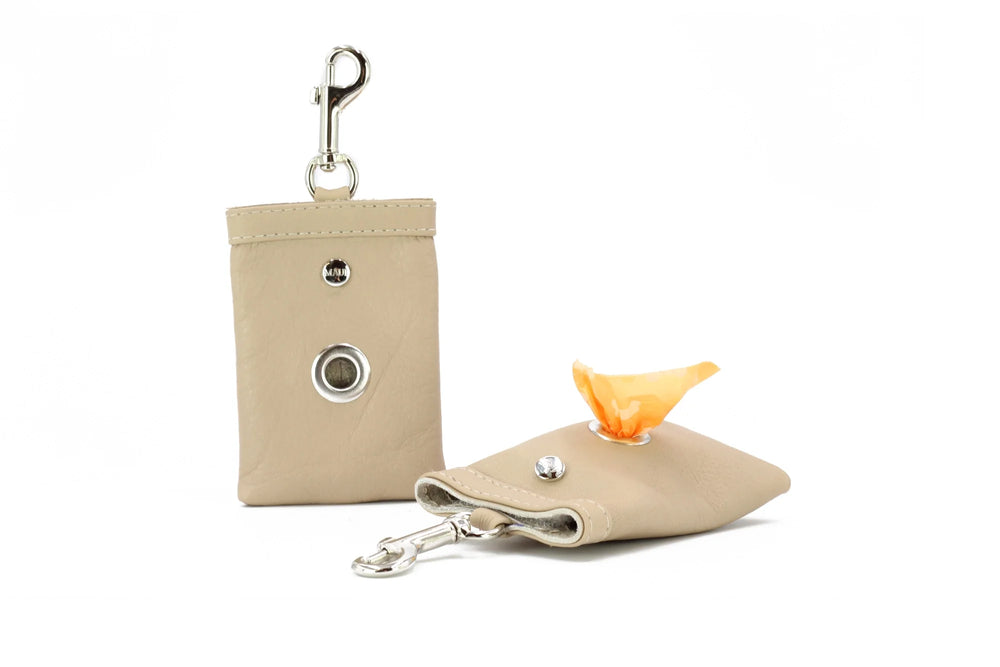 Beiger Leder-Schlüsselanhänger mit Karabinerhaken und aufklappbarer Tasche für Hundekotbeutel.