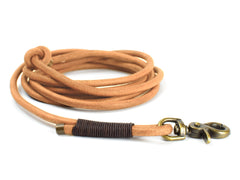 Braune Leder-Schleppleine für Hunde, spiralförmig gewickelt mit stabiler Karabinerhaken und rutschfestem Griff.