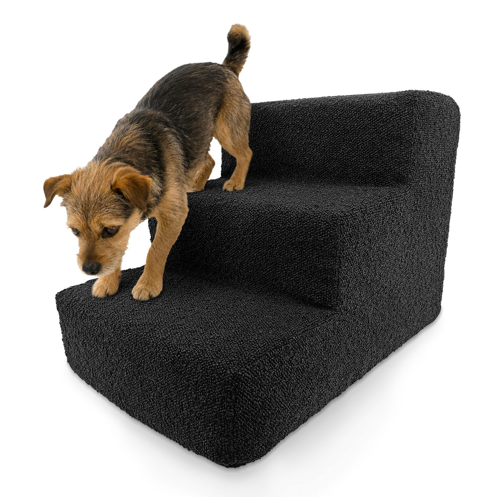 Hund auf einer schwarzen Haustiertreppe mit drei weichen Stufen aus Bouclé-Material.