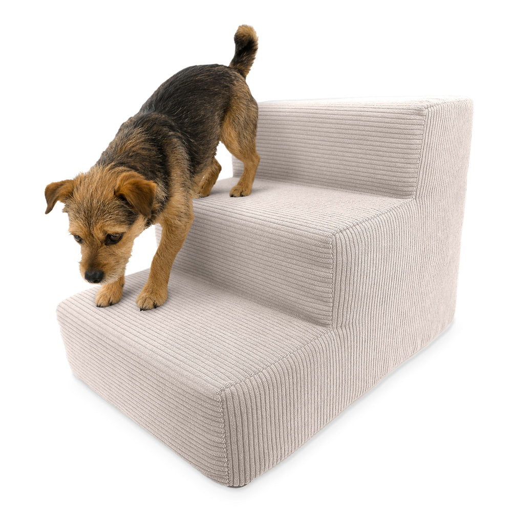 Kleine gepolsterte Haustiertreppe in hellem Samt mit Hund, der die moderne, geschwungene Treppe hinaufgeht.