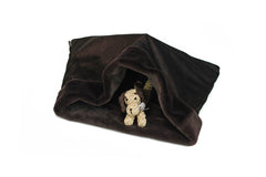 Gemütlicher Hunde-Schlafsack in Dunkelbraun mit einem süßen Hundestofftier darunter. Ideal für entspannte Momente.