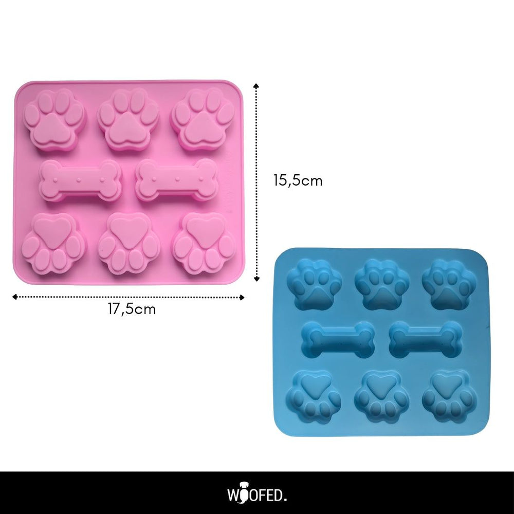 Zwei Silikonformen für Hundeleckerlis in Rosa und Blau mit Platz für Hundepfoten und Knochen, ideal für tierische Snacks.