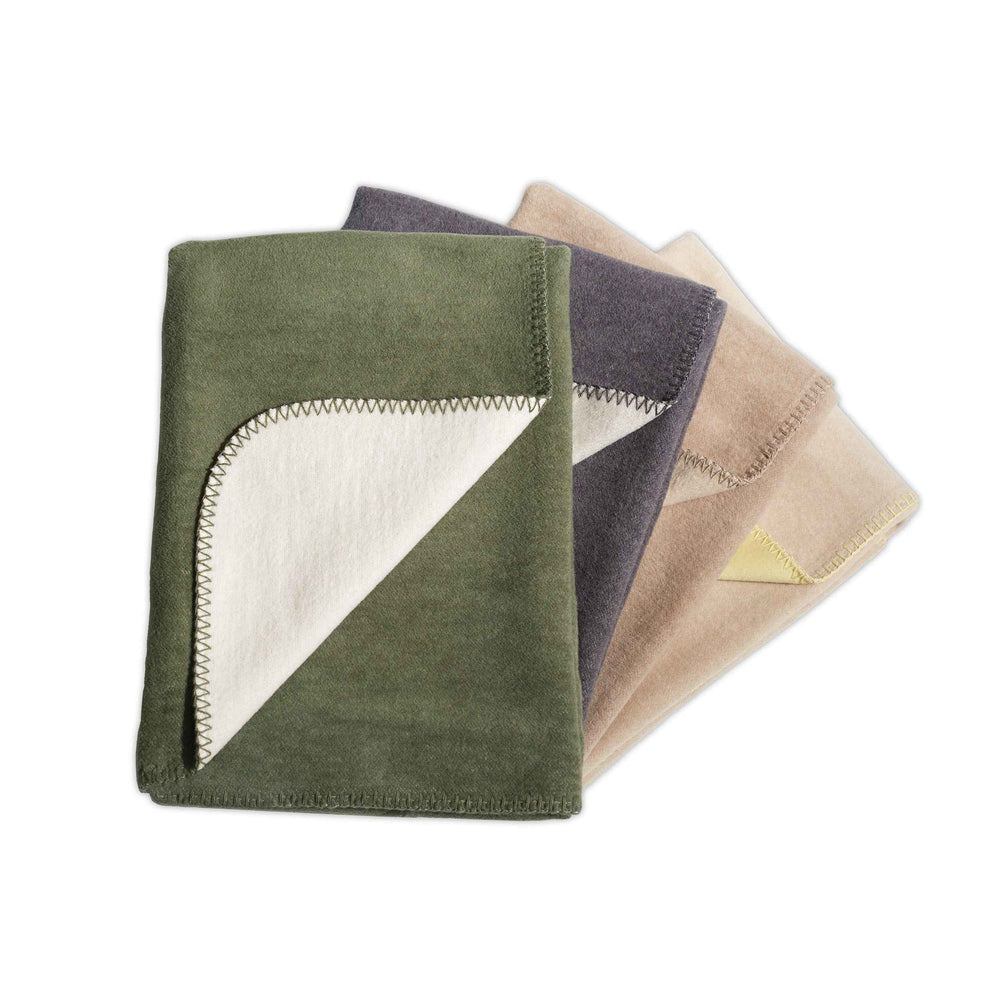Stilvolle REVERSO Wendedecke in Olivgrün, Grau und Beige, aus weichem Material, ideal für gemütliche Wohnräume.