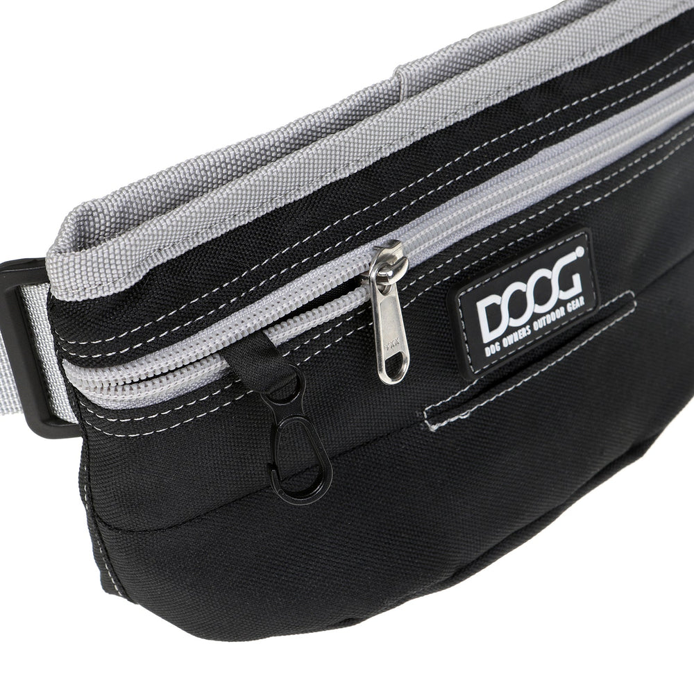 Schwarze DOOG Leckerchen-Tasche mit grauen Reißverschlussfächern und Logo, ideal für Hundetraining unterwegs.