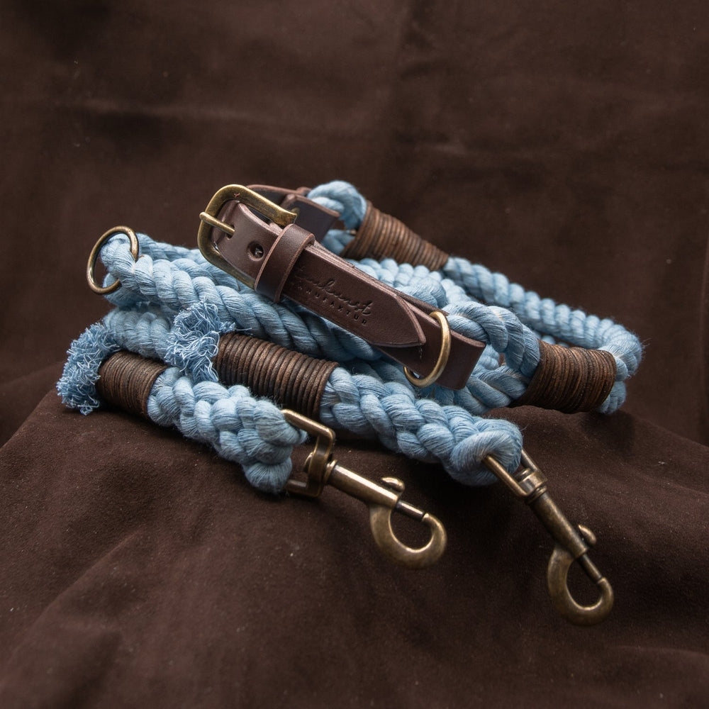 Blaue geflochtene Hundeleinen mit metallischen Karabinern und braunen Wickelelementen, perfekt für stylebewusste Hundehalter.